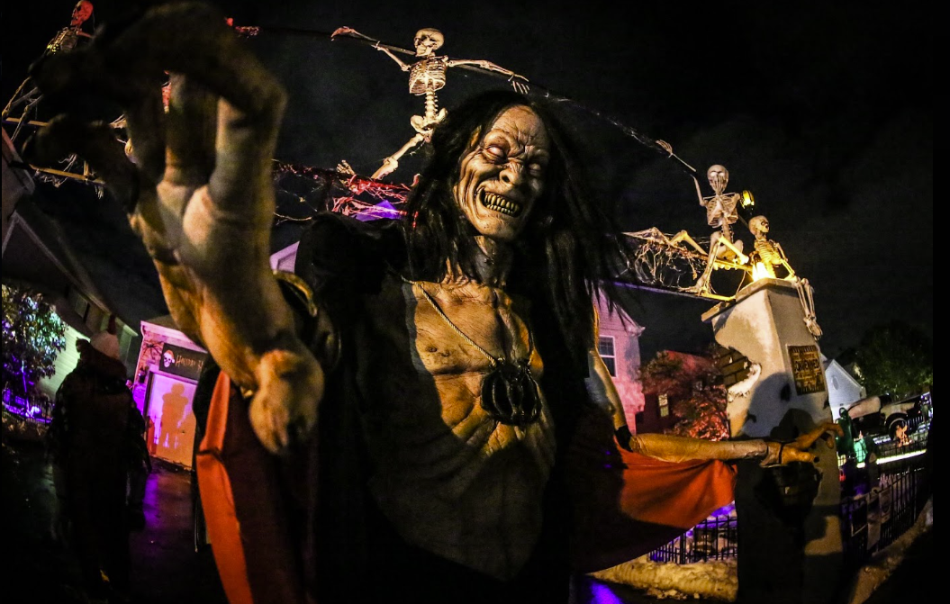 A towering Halloween creature prop reaching toward visitors at the Holiday Habits yard haunt in Huntley, Illinois