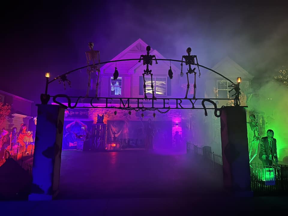 Holiday Habits cemetery arch with skeletons and colorful fog lighting at the Huntley yard haunt